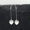 Heart dangle earrings on grey tile