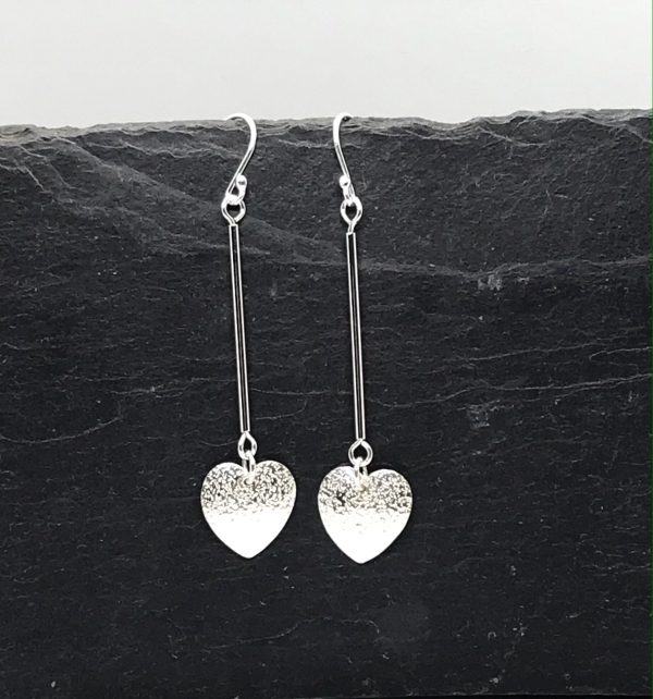 Heart dangle earrings on grey tile