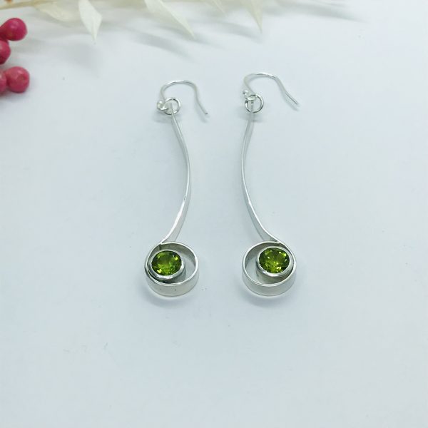 Peridot drop earrings on white background