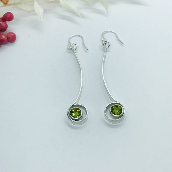 Peridot drop earrings on white background