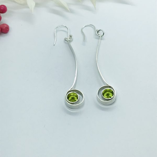 Peridot drop earrings on white background