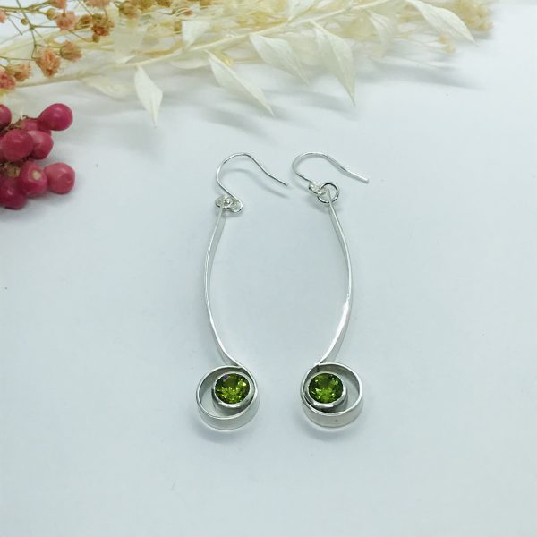 Peridot drop earrings on white background