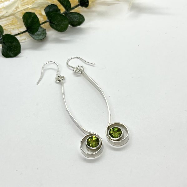 Peridot drop earrings on white background