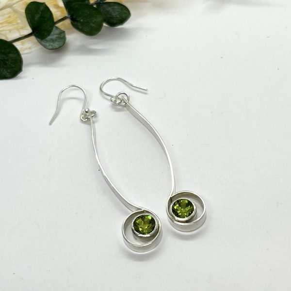 Peridot drop earrings on white background