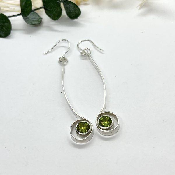 Peridot drop earrings on white background