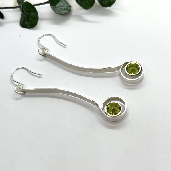 Peridot drop earrings on white background