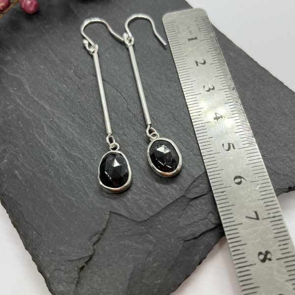 Black Tourmaline drop earrings on grey tile