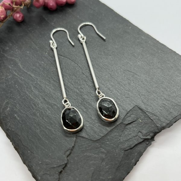 Black Tourmaline drop earrings on grey tile